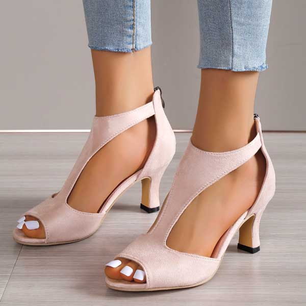 Sandali donna eleganti rosa con tacco medio, design aperto, cinturino alla caviglia, su pavimento in legno chiaro. Scarpe moda estive.