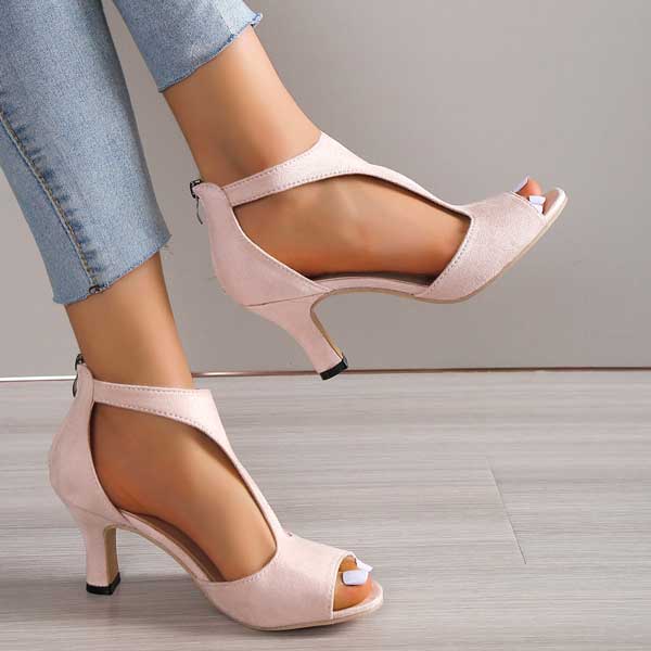 Scarpe col tacco aperte in punta color rosa, indossate con jeans. Eleganti sandali da donna, ideali per moda estiva e occasioni speciali.