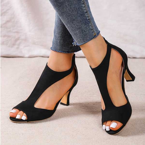 Scarpe col tacco aperte nere da donna, eleganti e moderne, indossate con jeans. Design sofisticato, perfette per occasioni formali e casual.