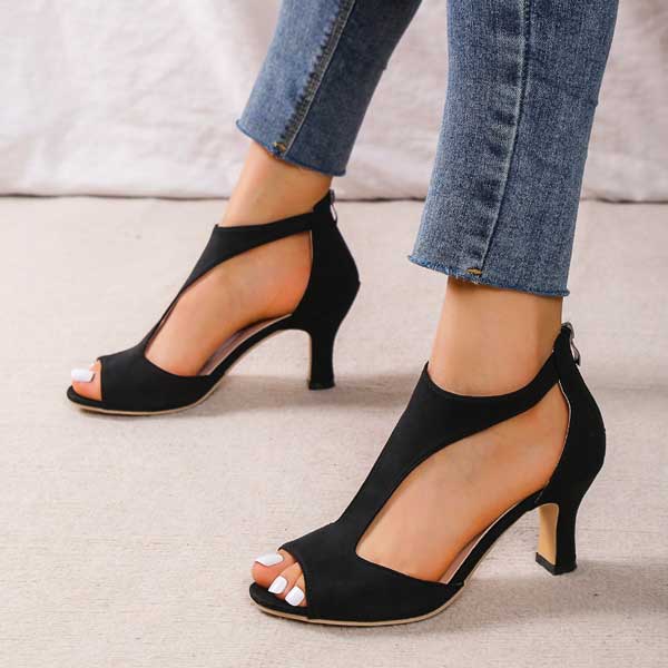Scarpe col tacco nere aperte in punta, indossate con jeans. Eleganti sandali da donna, ideali per moda estiva e occasioni formali.