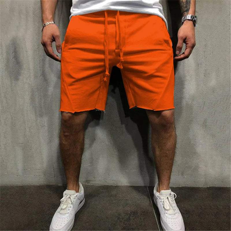 Shorts arancioni da uomo, casual e sportivi, con coulisse regolabile. Ideali per l'estate, abbinati a scarpe bianche. Moda maschile estiva.