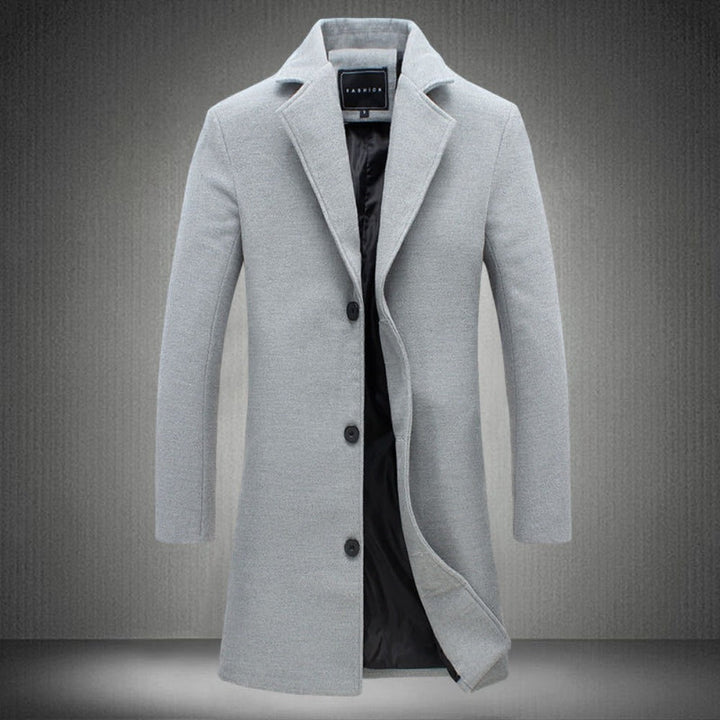 Cappotto uomo elegante grigio chiaro, lungo, con bottoni neri e fodera interna, ideale per moda invernale e look formale.