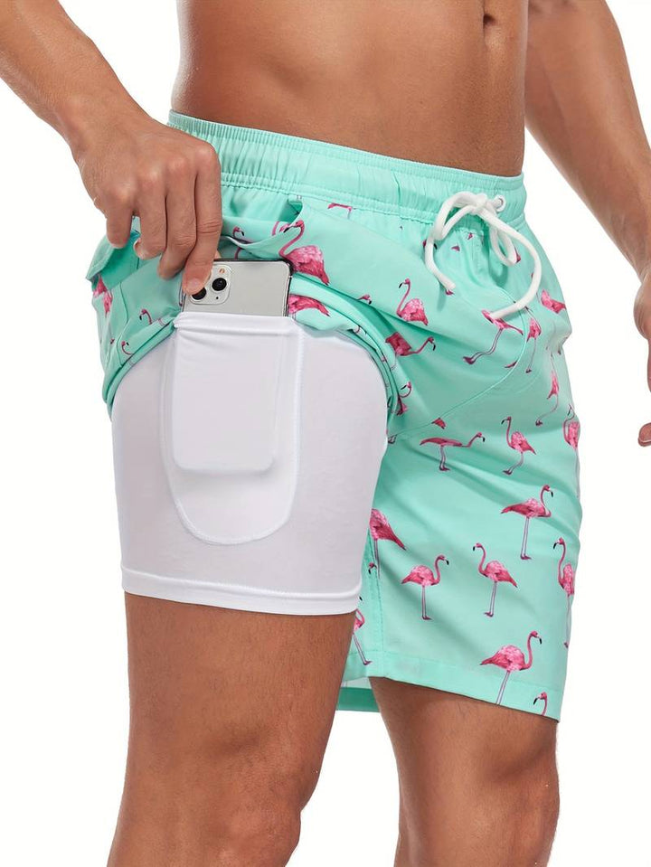Costume da bagno uomo verde acqua con fenicotteri rosa, tasca laterale per smartphone, design moderno, perfetto per spiaggia e piscina.