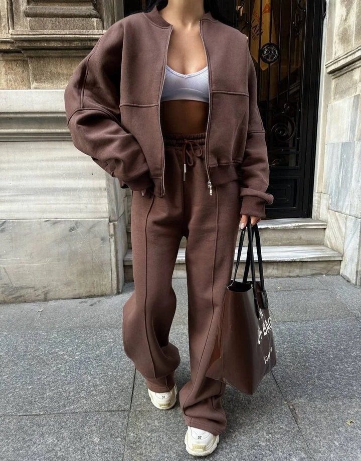 Ensemble de jogging femme gris avec veste ample, en tissu respirant, adapté pour les activités de loisirs et le sport.