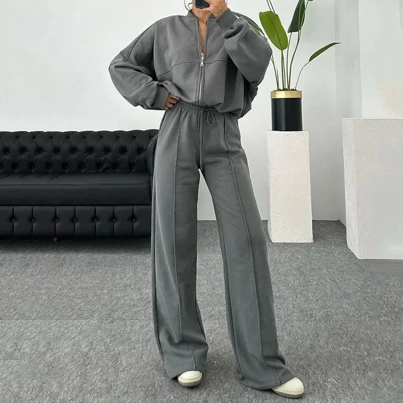 Ensemble de jogging femme gris avec veste ample et poignets élastiques. Confectionné en mélange de coton.