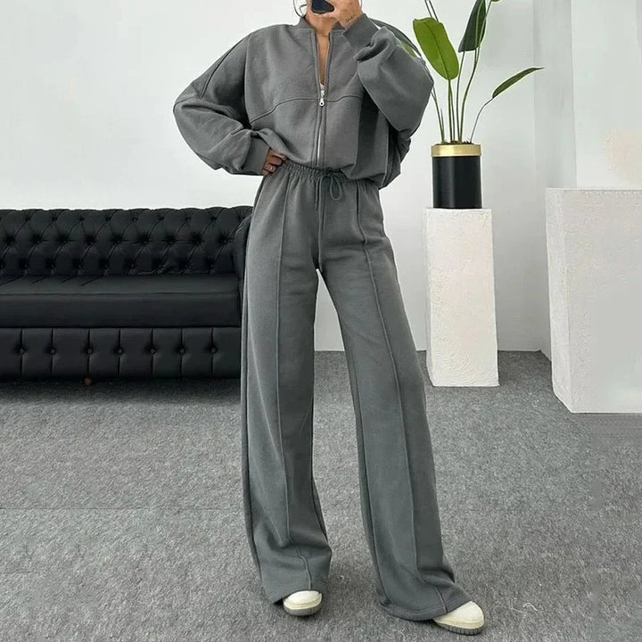 Ensemble de jogging femme gris avec veste ample et poignets élastiques. Confectionné en mélange de coton.