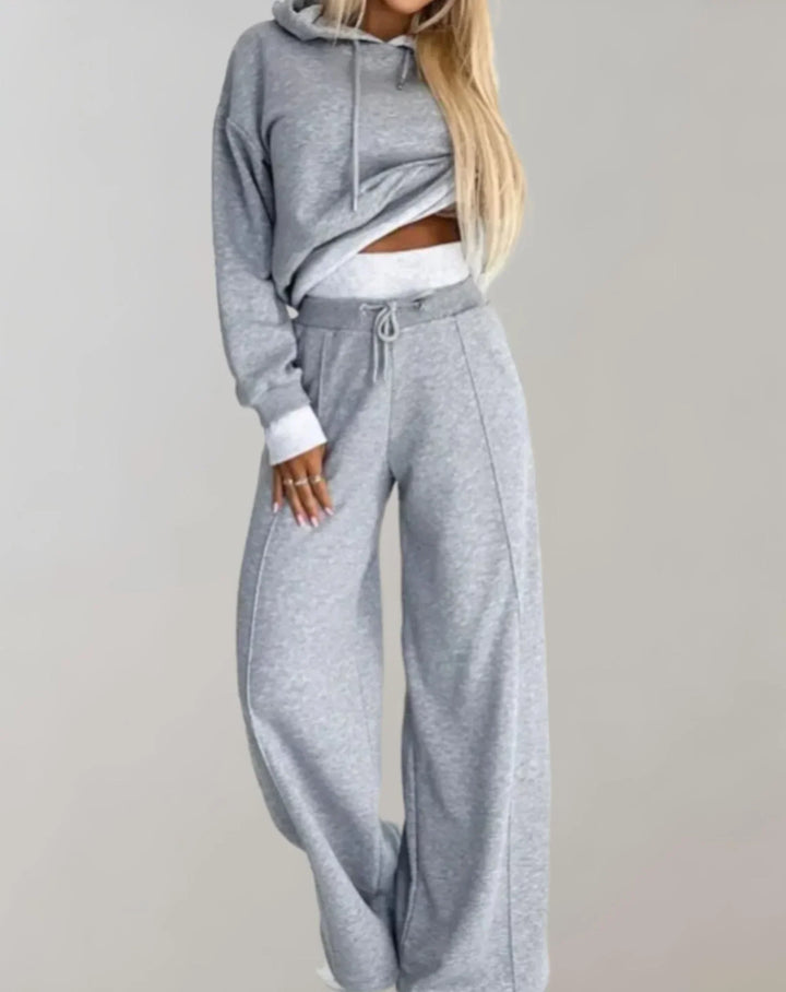 Ensemble deux pièces femme en coton noir avec capuche et pantalon ample, conçu pour un style décontracté.