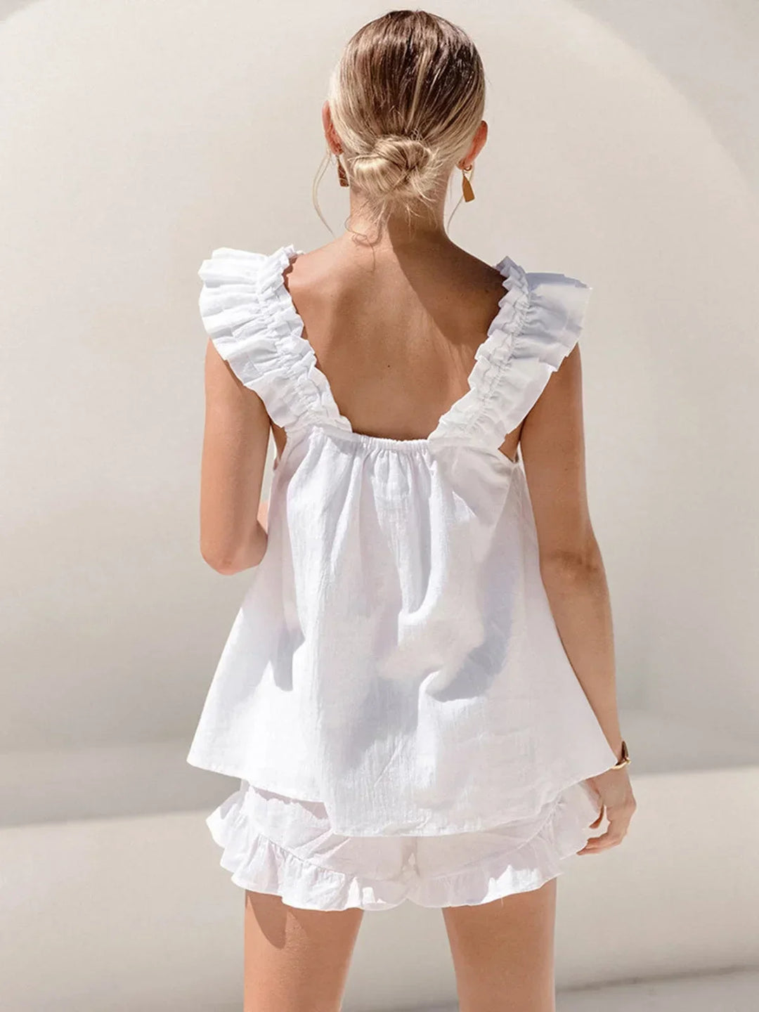 Ensemble femme en tissu léger, haut sans manches à volants avec un short assorti, parfait pour les journées estivales.