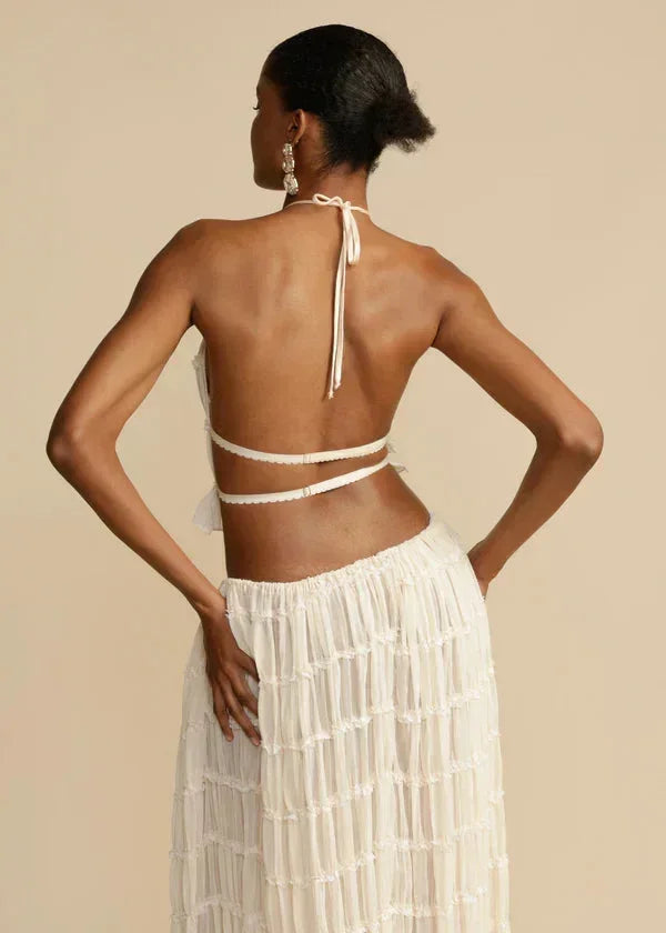 Ensemble femme ivoire en tissu léger, composé d'une jupe fluide et d'un haut à volants délicats pour un look élégant.