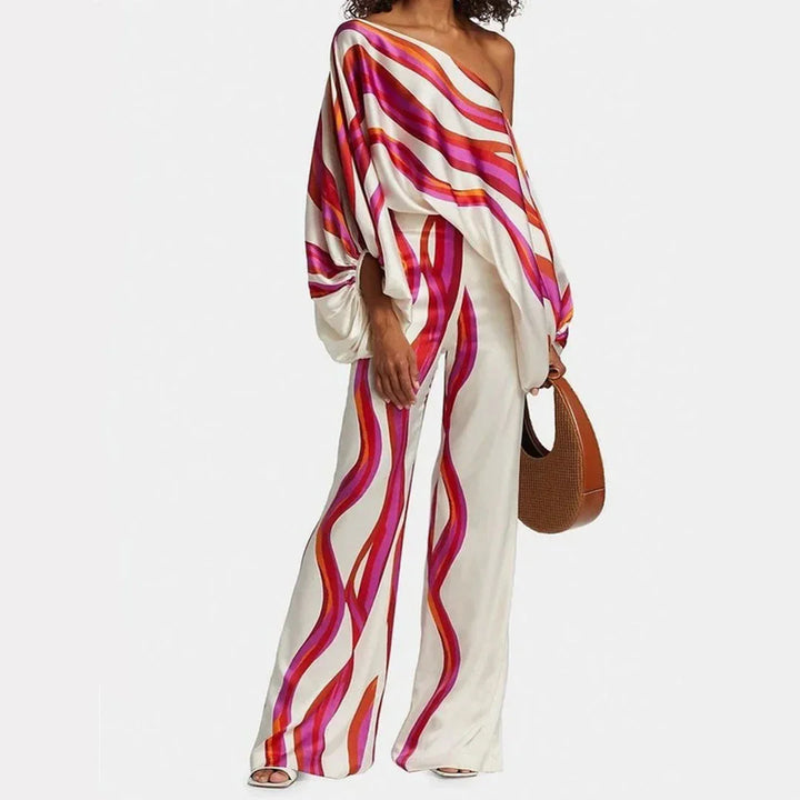 Ensemble femme fuchsia en tissu léger, avec manches tombantes et pantalon droit, idéal pour un look décontracté.