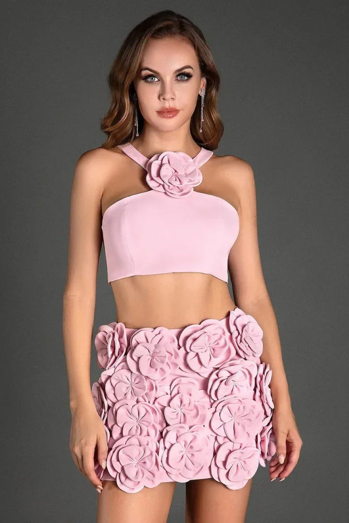 Ensemble femme rose en tissu léger avec top dos nu et délicats appliqués floraux pour une allure estivale.