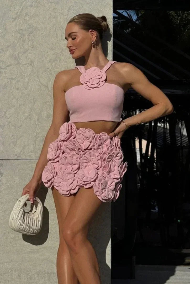 Ensemble femme rose en tissu léger, top dos nu avec appliqués floraux délicats et coupe élégante.