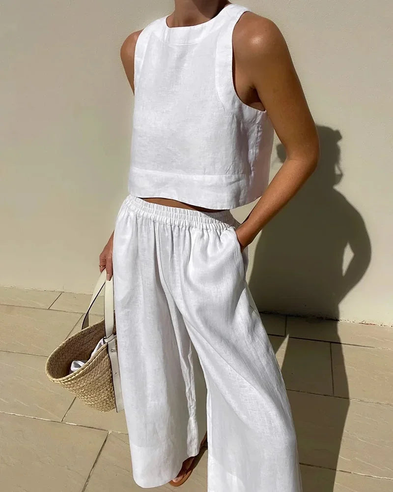 Ensemble femme sans manches blanc, en tissu léger, avec un top court et pantalon fluide pour un confort optimal.