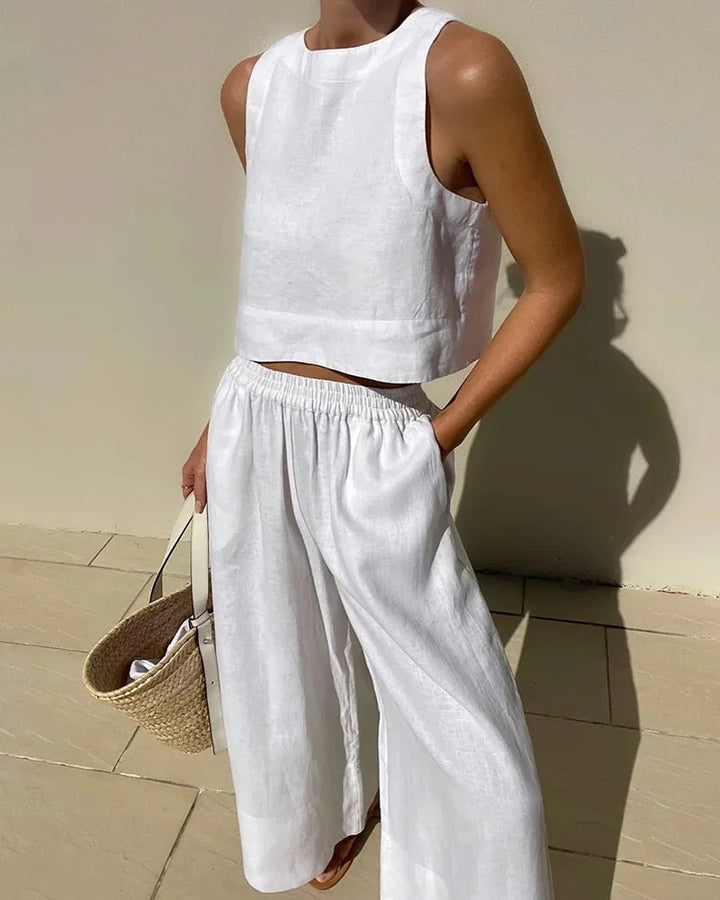 Ensemble femme sans manches blanc, en tissu léger, avec un top court et pantalon fluide pour un confort optimal.
