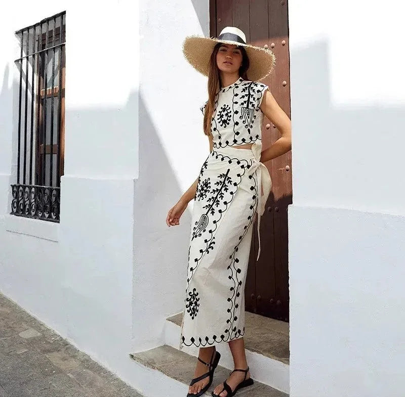Ensemble femme sans manches en coton brodé, comprenant un haut léger et une jupe fluide aux motifs délicats.