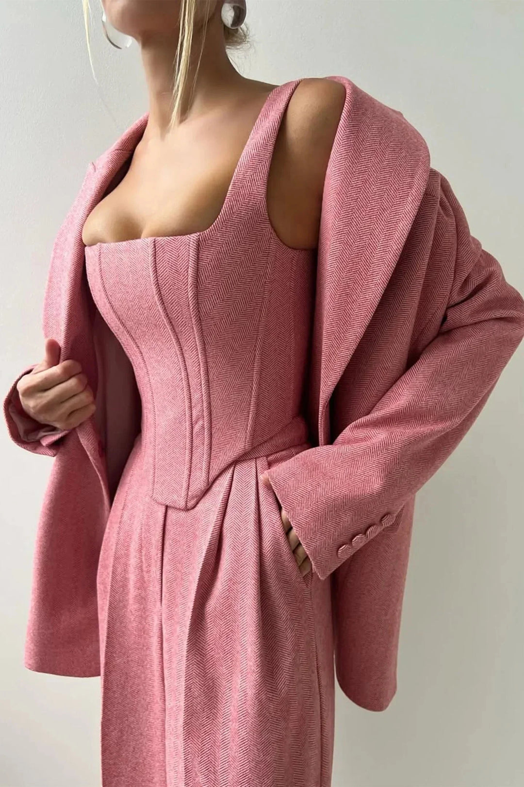Ensemble femme trois pièces en tissu élastique, comprenant un haut ajusté, un rock et un blazer noir au design soigné.