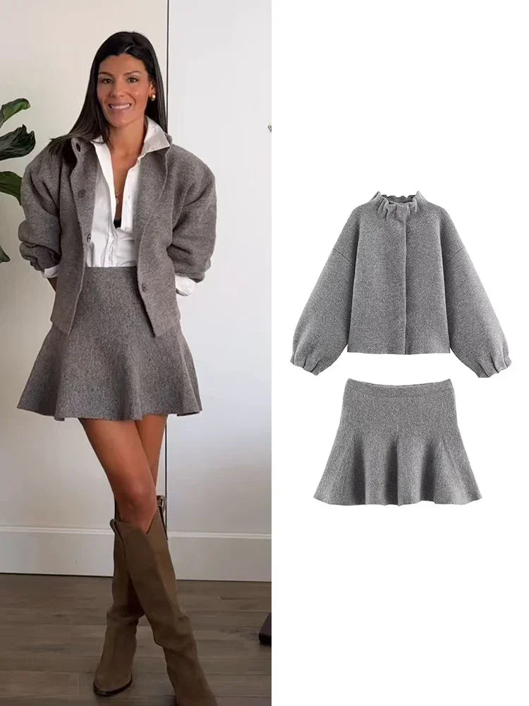 Ensemble gris femme composé d'une jupe courte et d'une veste longue à manches, en tissu léger.