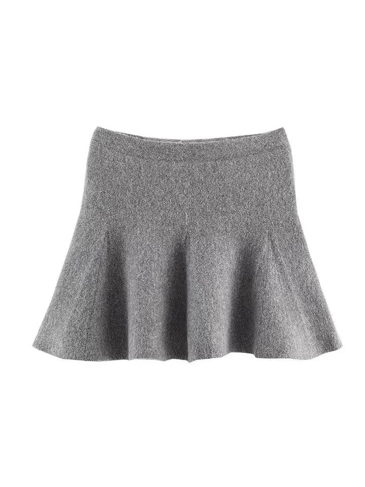 Ensemble gris femme avec jupe courte et veste longue cintrée à manches longues.