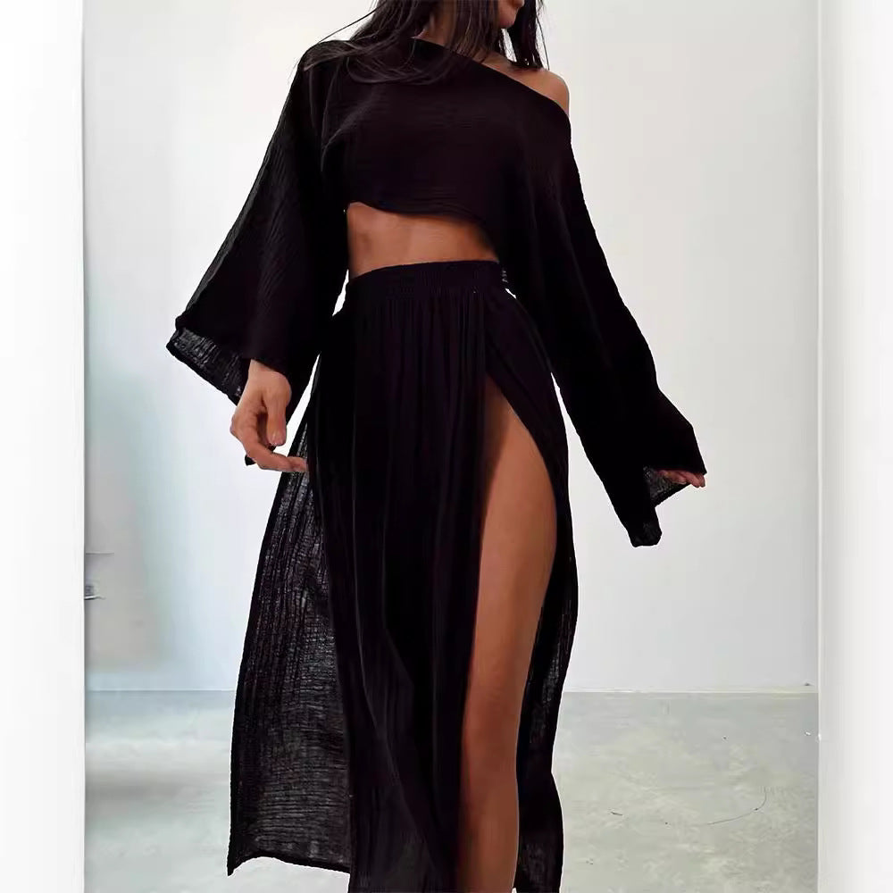 Abito nero elegante con spacco alto, maniche lunghe e scollo asimmetrico. Moda donna, abbigliamento trendy, stile sofisticato.