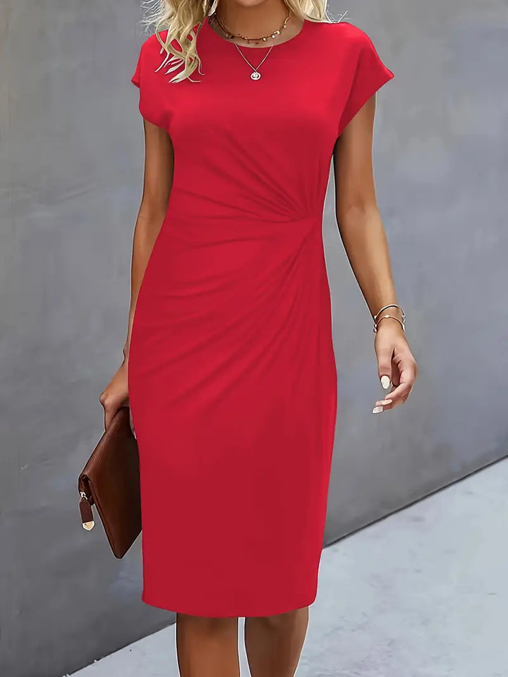 Abito rosso elegante da donna, maniche corte, lunghezza al ginocchio, adatto per occasioni formali. Accessori: collana e borsa marrone.