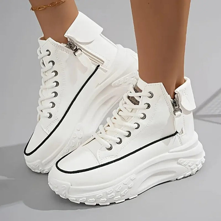Scarpe da ginnastica bianche alte con suola spessa, dettagli in nero e cerniera laterale. Design moderno e alla moda per un look casual e sportivo.
