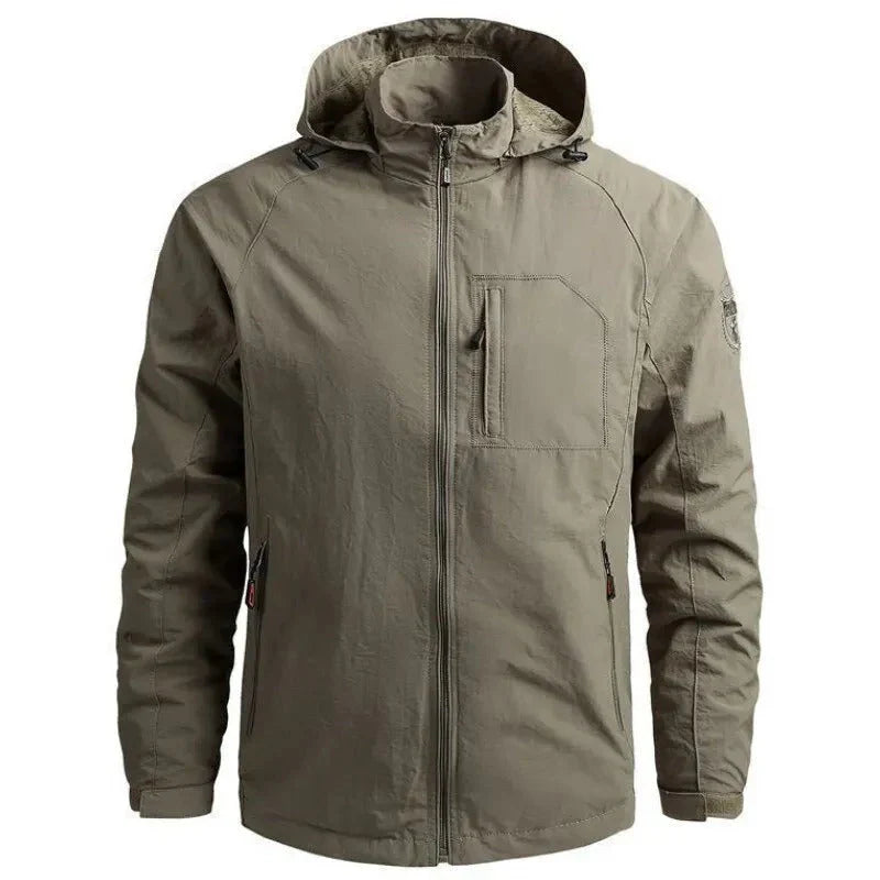 Giacca impermeabile verde oliva con cappuccio, tasche con zip, design casual, ideale per outdoor e trekking. Tessuto resistente e antivento.