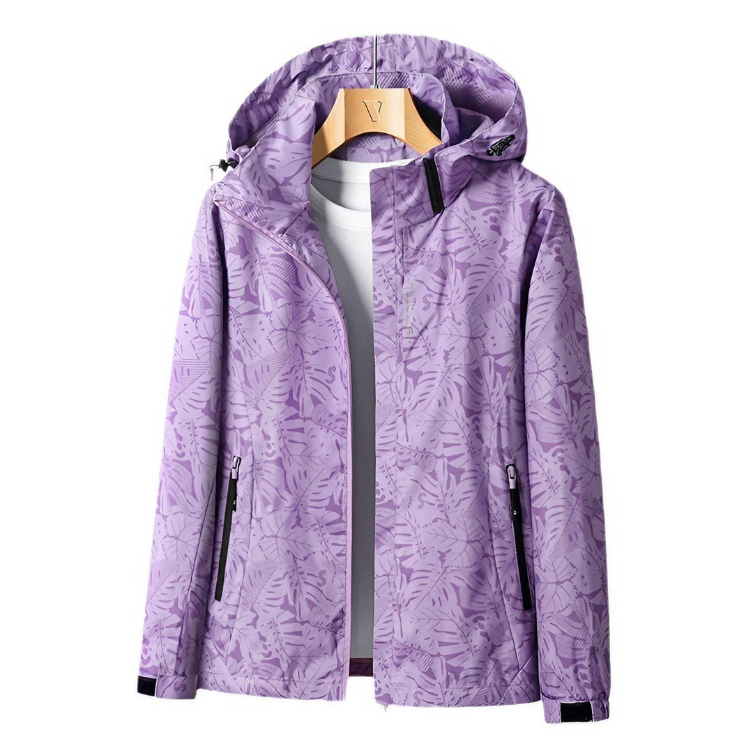 Giacca impermeabile viola con cappuccio, motivo foglie, chiusura zip, tasche laterali, ideale per outdoor e sport. Disponibile su Google Shopping.