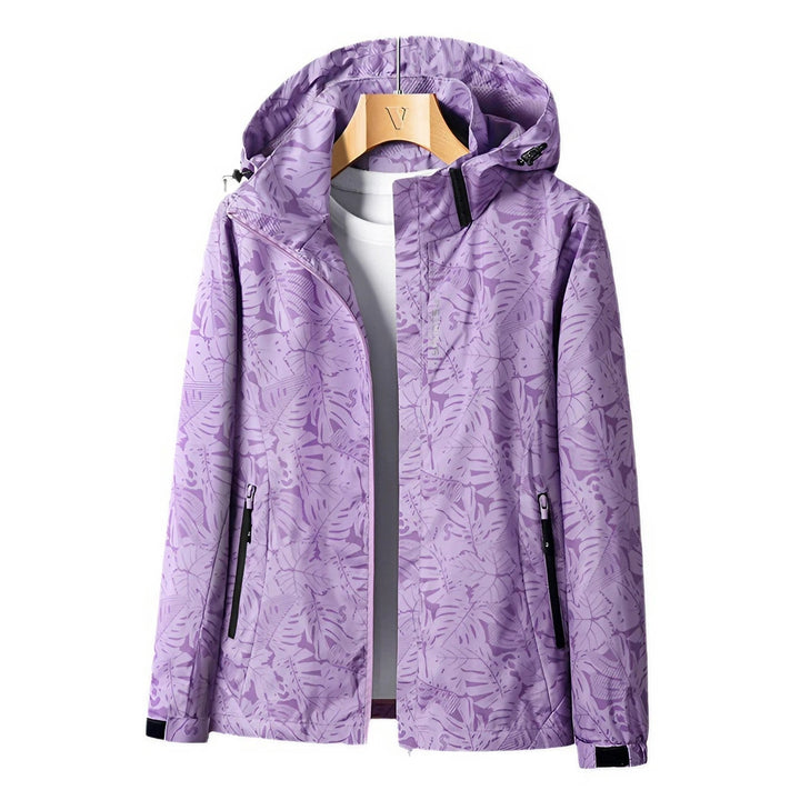 Giacca impermeabile viola con cappuccio, motivo foglie, chiusura zip, tasche laterali, ideale per outdoor e sport. Disponibile su Google Shopping.
