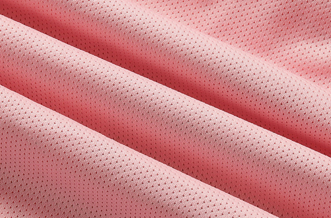 Tessuto a rete rosa, traspirante e leggero, ideale per abbigliamento sportivo e accessori moda. Materiale resistente e di alta qualità.