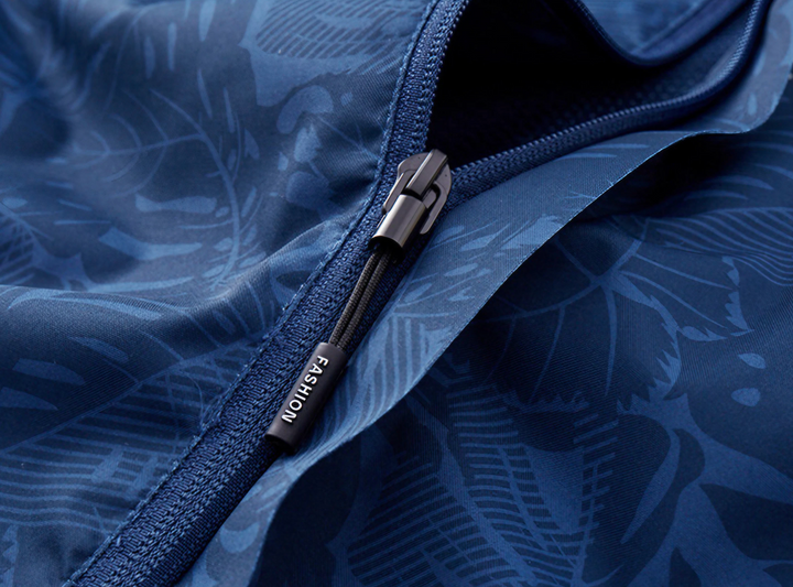 Giacca blu con cerniera, motivo floreale, tessuto impermeabile. Design elegante, ideale per moda outdoor. Accessorio con etichetta "Fashion".