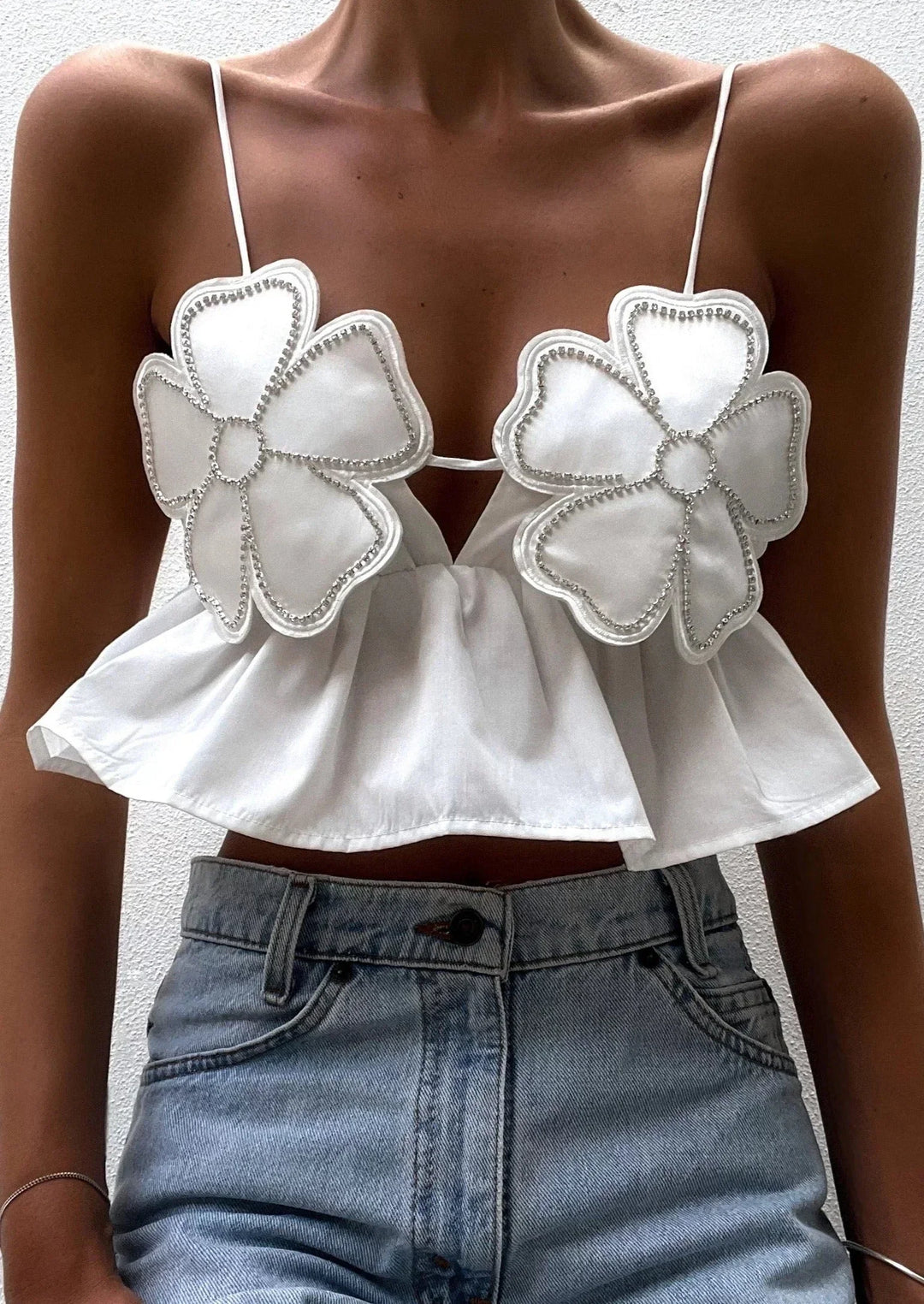 Haut court femme en coton léger, avec appliques florales et bretelles fines, parfait pour un look estival décontracté.