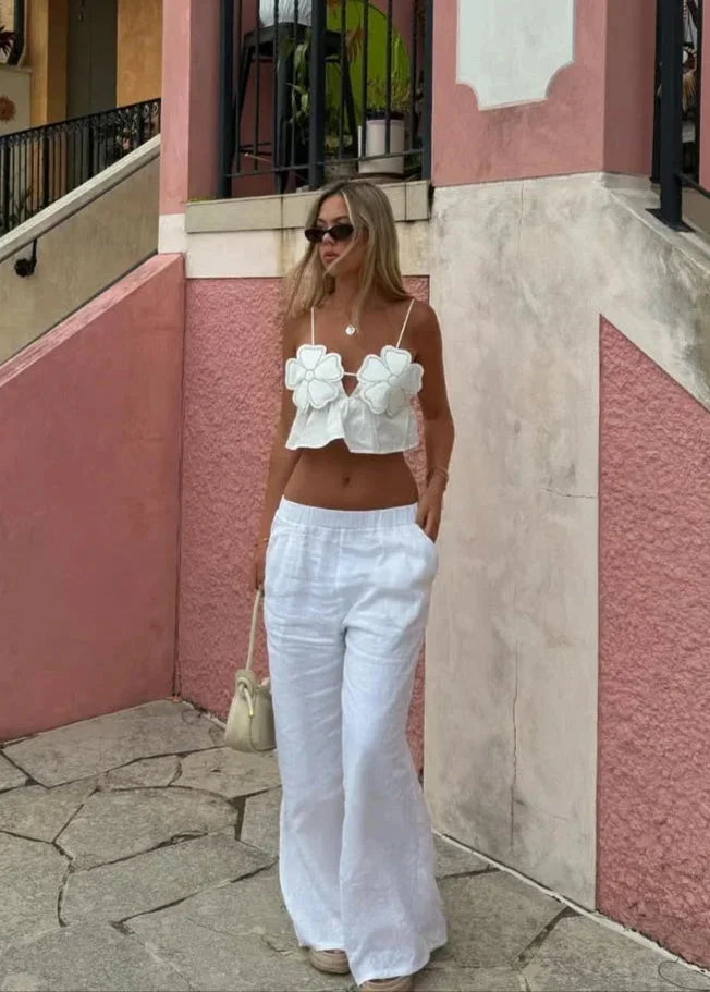 Haut court femme en coton léger, décoré d'appliques florales, avec fines bretelles pour un style délicat et féminin.