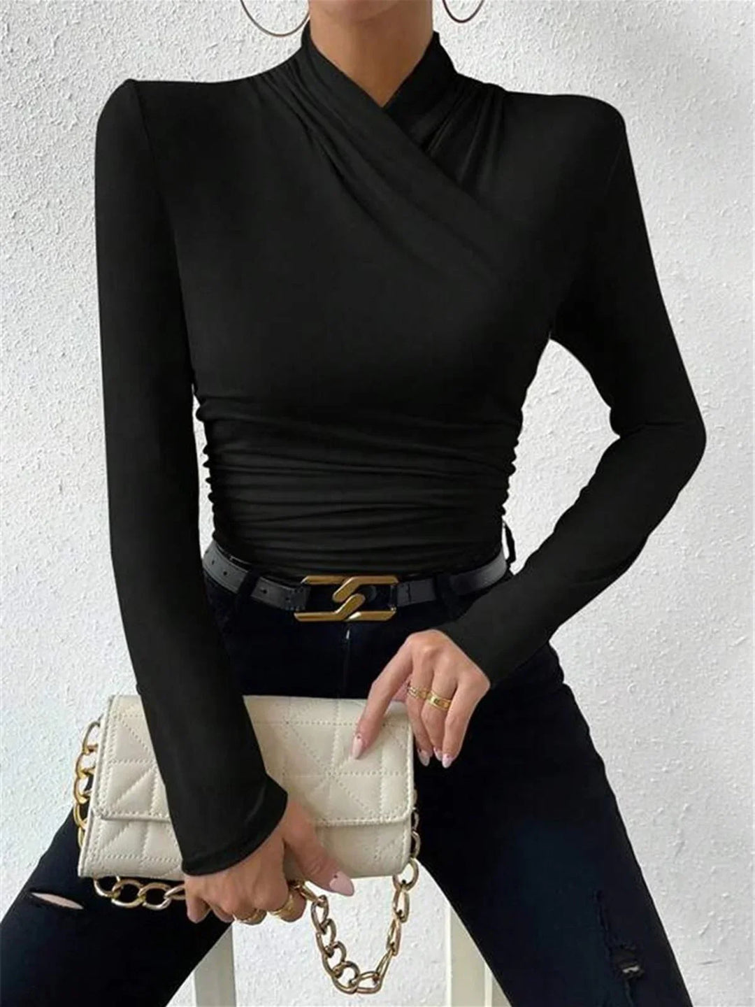 Haut noir croisé à manches longues avec drapés et décolleté en V.