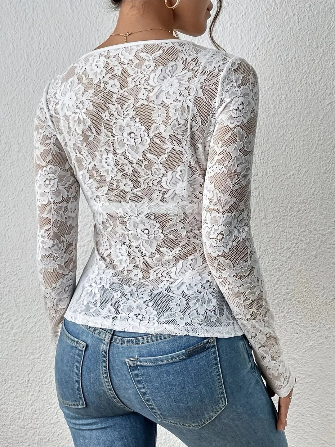 Haut en dentelle blanche, manches longues, col V, adaptée pour des occasions festives ou quotidiennes.
