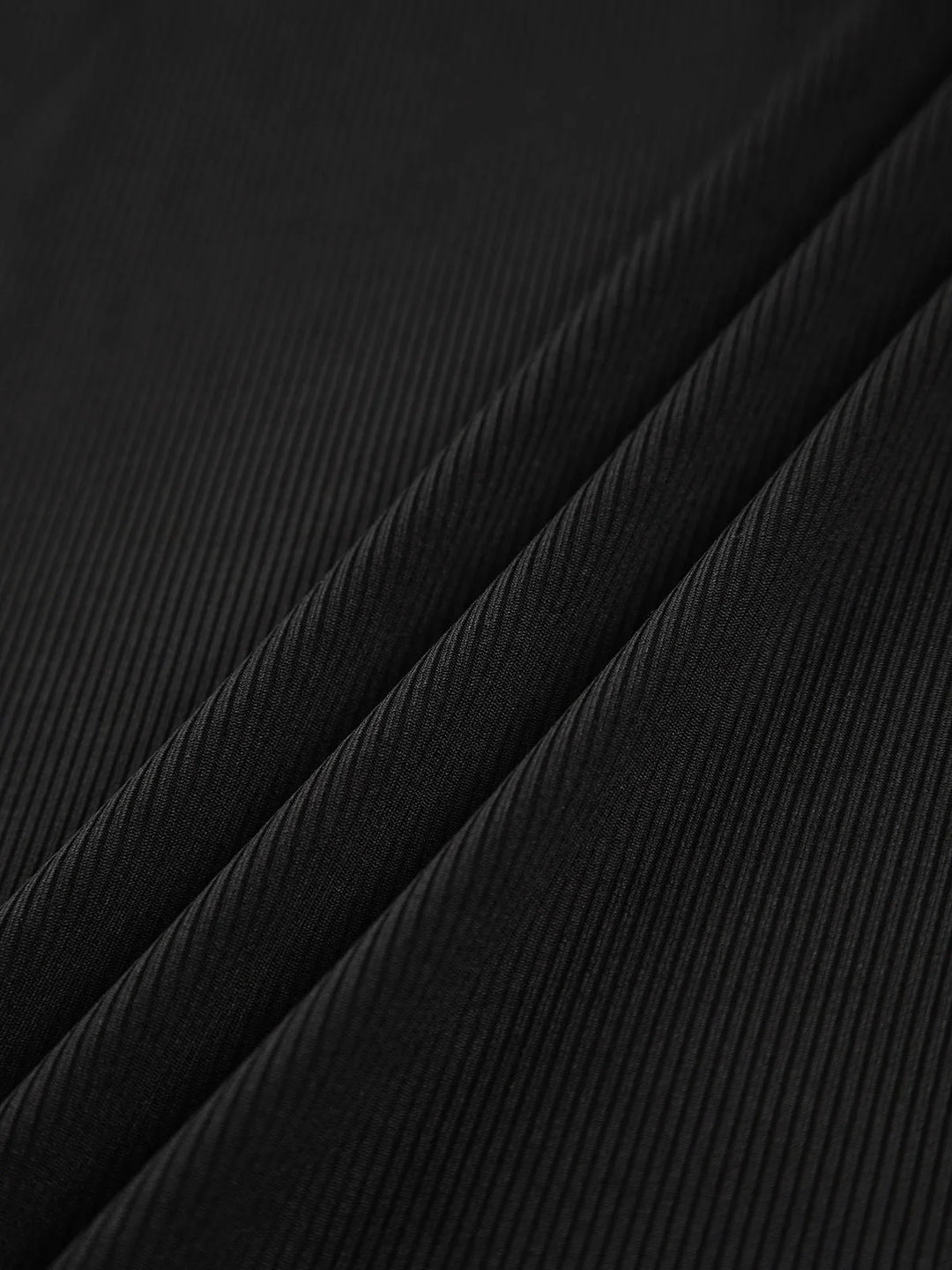 Haut femme asymétrique noir à col montant et découpe, en tissu doux et respirant.