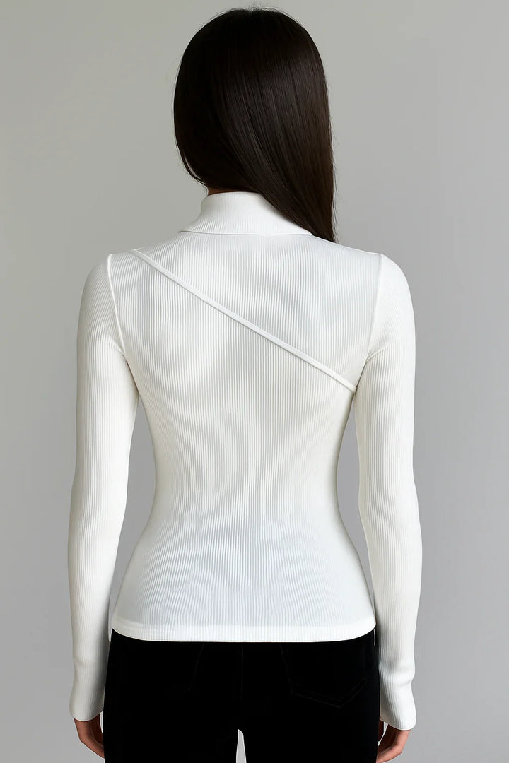 Haut femme blanche col montant, manches longues et tissu extensible pour un confort et une liberté de mouvement.