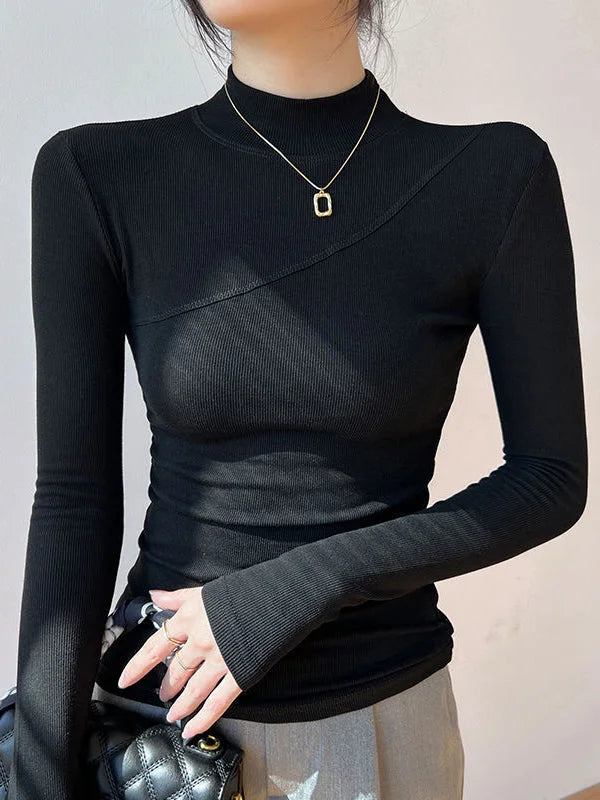 Haut femme noir à col montant, manches longues et tissu extensible pour un ajustement confortable.