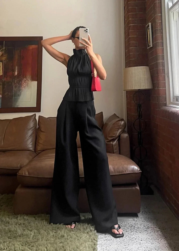 Haut femme dos-nu en tissu léger, orné de détails en chaîne métallique pour un look moderne et élégant.