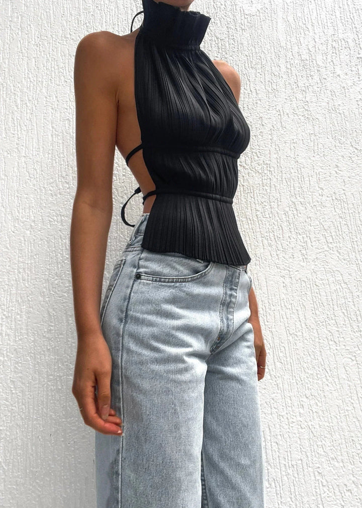 Haut femme dos-nu en tissu léger, détails chaîne métallique pour une touche élégante et moderne. Parfait pour les soirées.