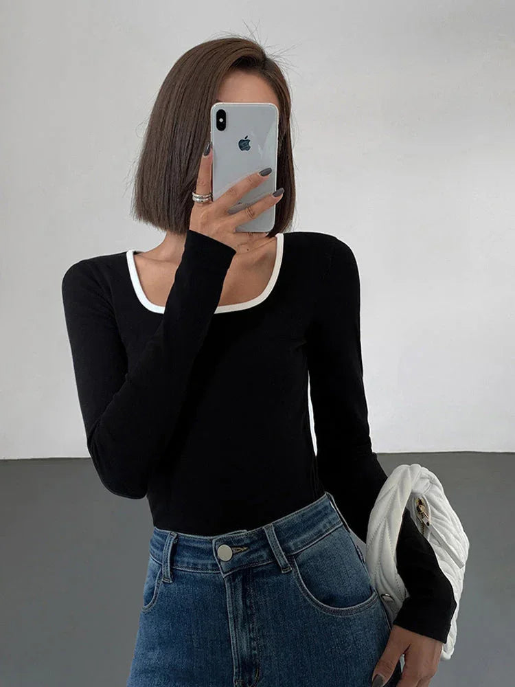 Haut femme noire à encolure carrée, bordures contrastées, en tissu léger et respirant.