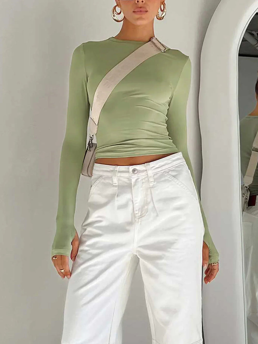 Haut femme vert clair à manches longues, coupe ajustée en tissu extensible pour un confort optimal.