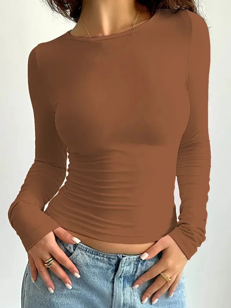 Haut femme gris, moulant, à manches longues et col rond, en tissu doux et extensible.