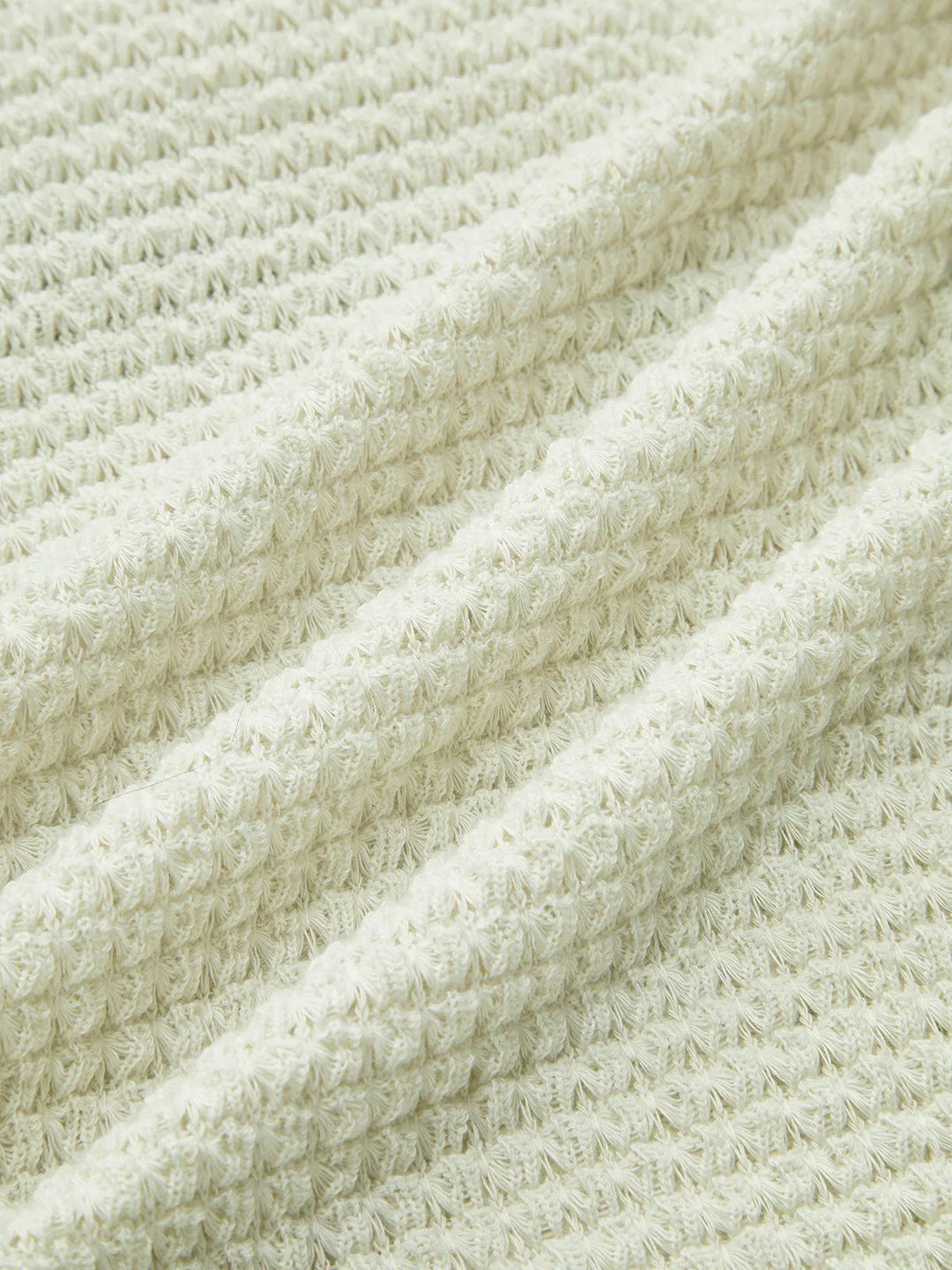 Haut noir à manches longues en maille texturée avec un motif délicat et une coupe confortable pour le quotidien.