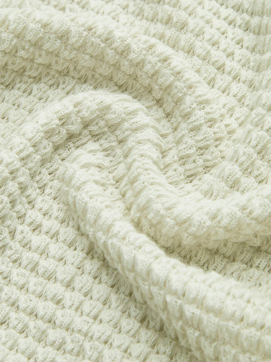 Haut noir à manches longues en maille texturée, adapté pour des tenues d'automne.