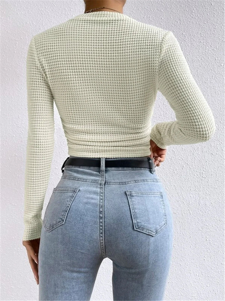 Haut beige à manches longues en maille texturée, coupe décontractée, idéal pour des looks variés.