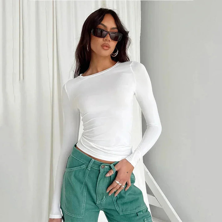 Haut slim femme blanc à manches longues extensibles en tissu doux, adapté pour un port confortable au quotidien.