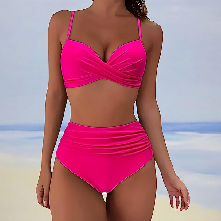 Donna in bikini rosa acceso, design a vita alta, sfondo spiaggia. Costume da bagno estivo, moda mare, abbigliamento donna.