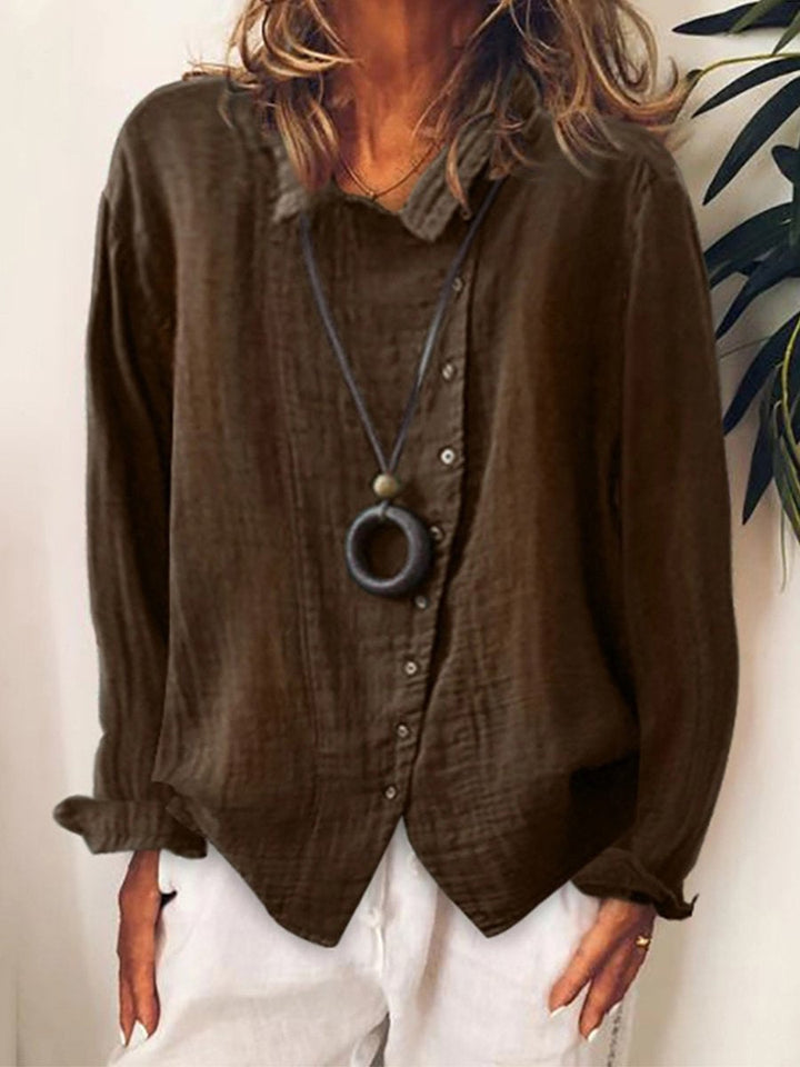 Camicia marrone da donna in lino, maniche lunghe, colletto classico, abbinata a collana nera. Stile casual elegante, perfetta per l'autunno.