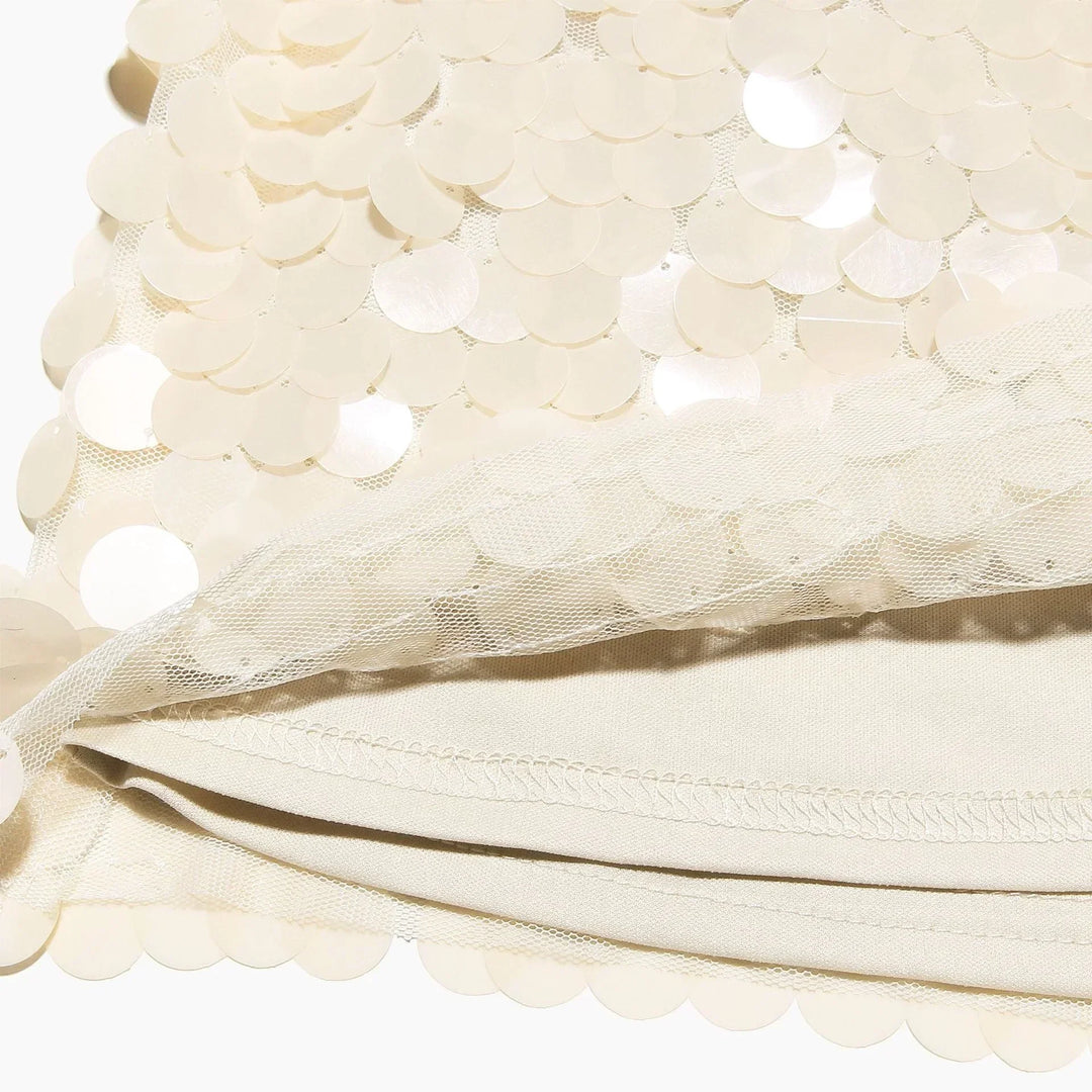 Jupe courte ivoire à sequins, conçue en tissu léger, avec un design scintillant et une coupe flatteuse pour toutes occasions.