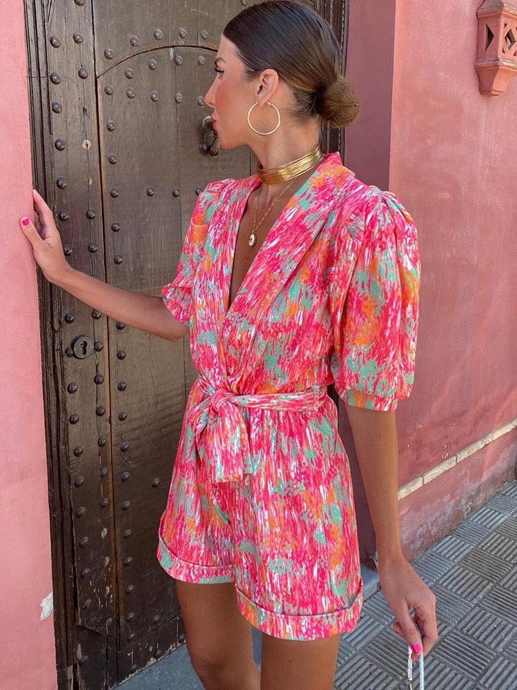 Donna con abito estivo colorato, fantasia astratta, davanti a porta in legno. Moda femminile, abbigliamento estivo, tendenze 2023.